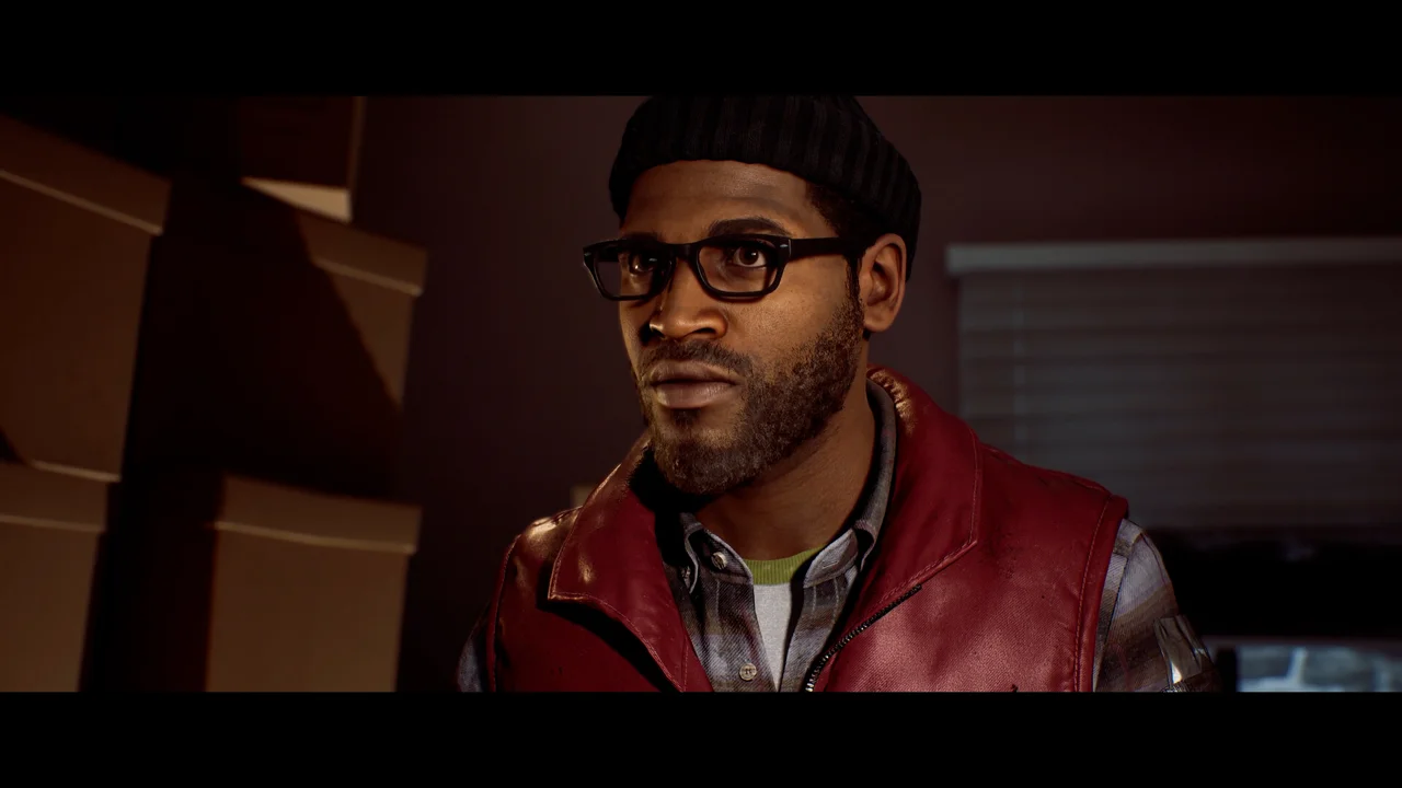 Close-up of a man in a black knit cap, glasses and a red leather vest, standing outside in fog